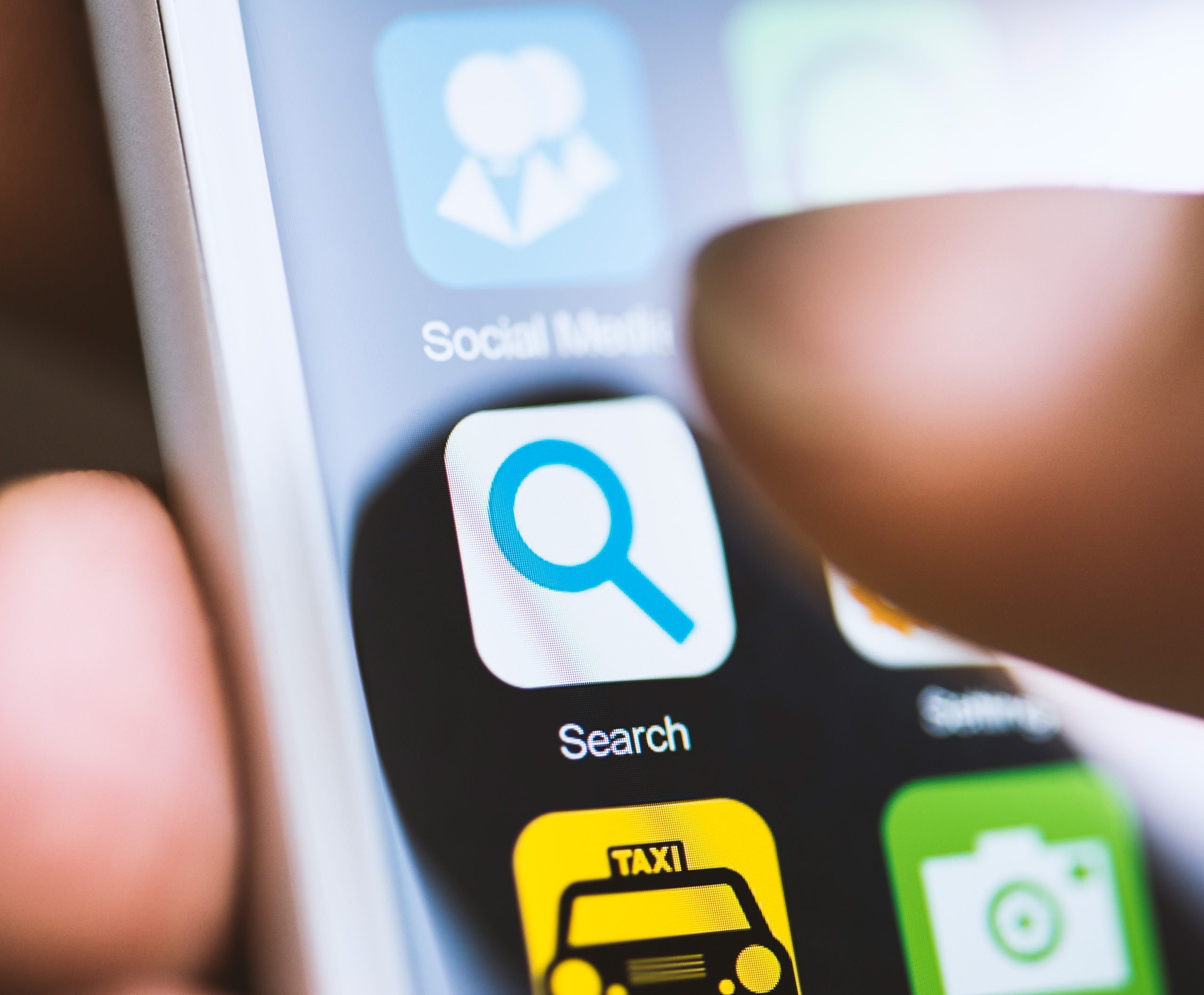 Persoon die op smartphone tapt op 'Search'